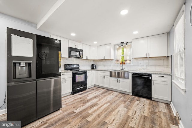 kitchen with black appliances, sink, light wood-type flooring, backsplash, and white cabinets