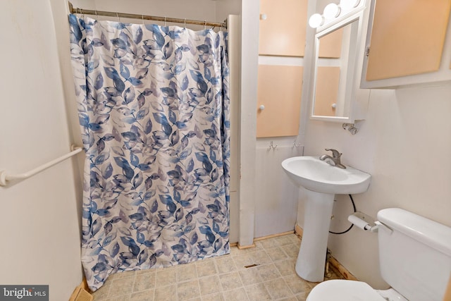 bathroom with toilet, sink, and a shower with curtain