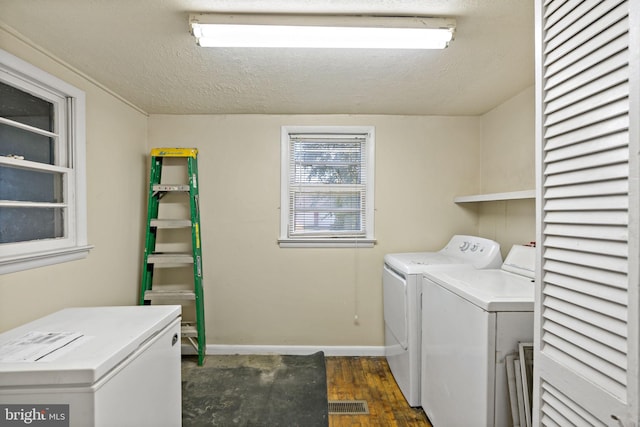 laundry area featuring independent washer and dryer, a textured ceiling, and dark hardwood / wood-style flooring