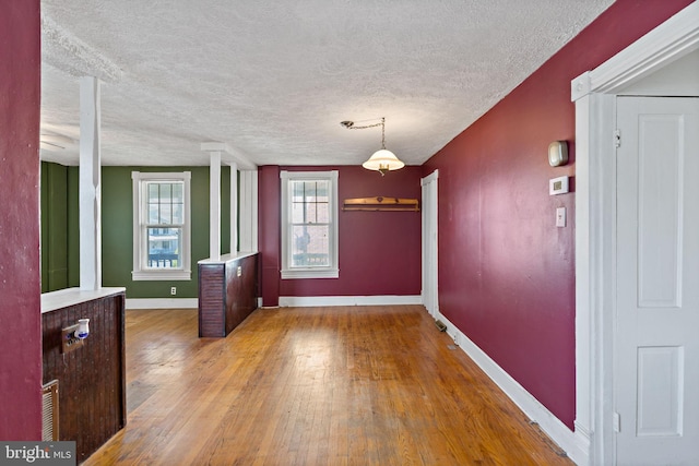 unfurnished dining area featuring hardwood / wood-style floors and a textured ceiling