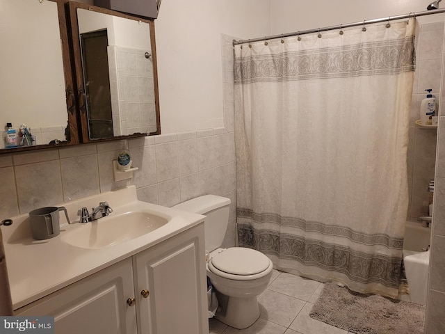 full bathroom featuring tile patterned floors, shower / bath combo, toilet, vanity, and tile walls