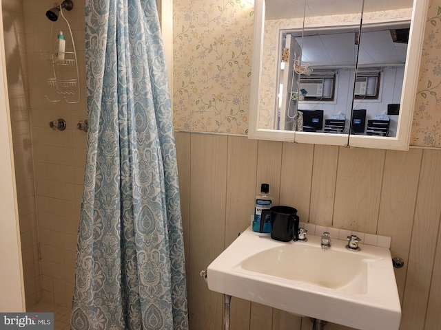 bathroom with wood walls, sink, and a shower with shower curtain