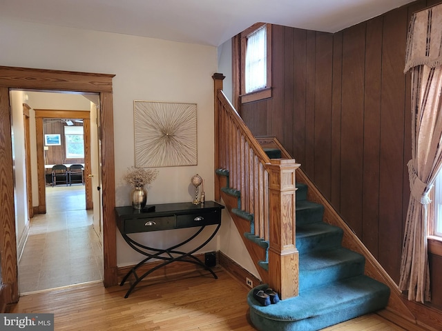 stairway featuring hardwood / wood-style flooring and wood walls