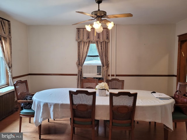 dining area featuring light hardwood / wood-style flooring, cooling unit, and ceiling fan