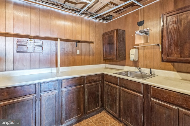 kitchen featuring sink and wooden walls