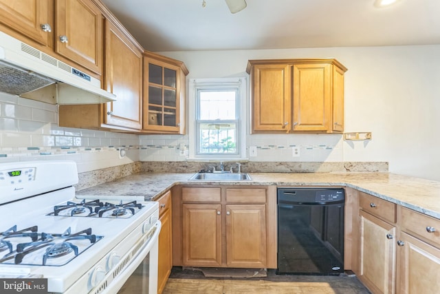 kitchen featuring decorative backsplash, black dishwasher, white gas stove, light stone countertops, and sink