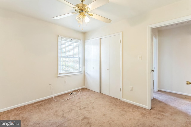 unfurnished bedroom featuring light carpet, a closet, and ceiling fan