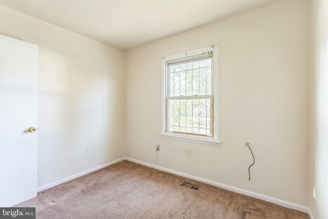 spare room featuring light colored carpet