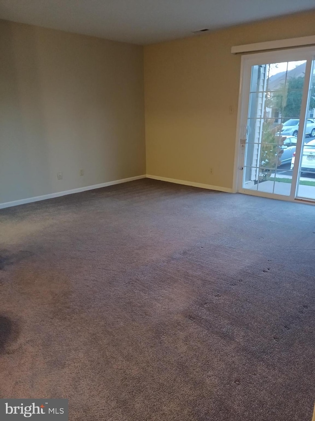 spare room with dark carpet