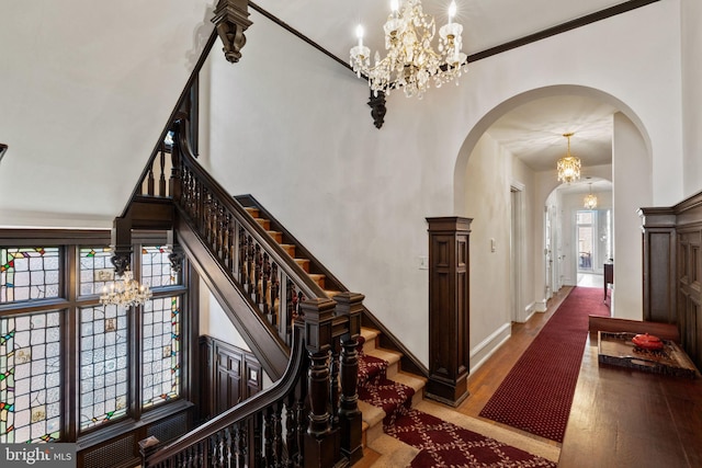 staircase featuring hardwood / wood-style flooring, a towering ceiling, and crown molding