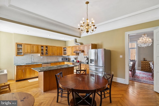 dining room with sink, crown molding, light parquet floors, and an inviting chandelier