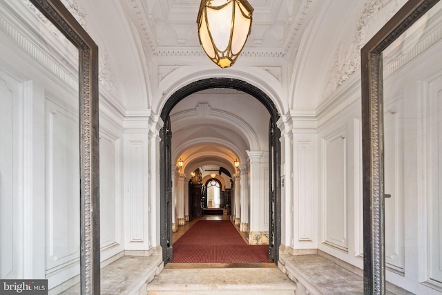 hall with ornate columns and crown molding