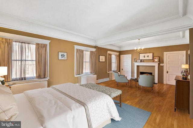 bedroom featuring a chandelier, multiple windows, crown molding, and light hardwood / wood-style flooring