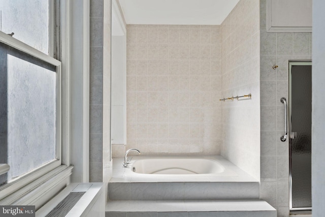 bathroom featuring independent shower and bath and tile walls