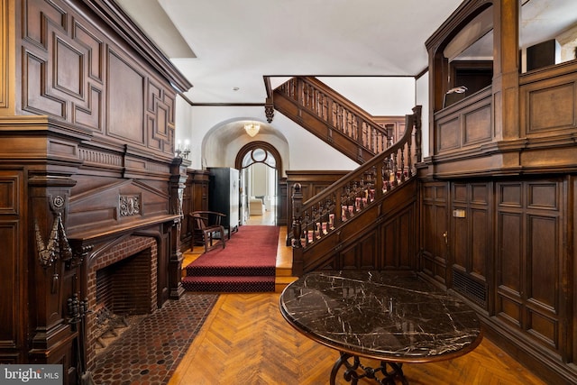 stairs featuring ornamental molding and parquet floors