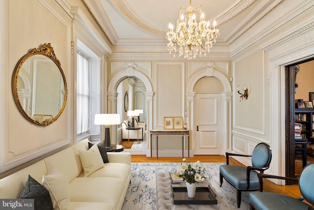 sitting room featuring hardwood / wood-style flooring, a chandelier, a healthy amount of sunlight, and ornamental molding