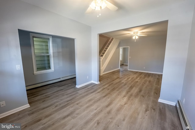 empty room with light hardwood / wood-style flooring, baseboard heating, and ceiling fan