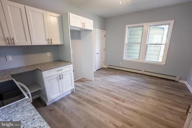 kitchen with a baseboard heating unit, light hardwood / wood-style flooring, range, white cabinets, and light stone counters