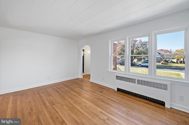 empty room featuring radiator and light wood-type flooring