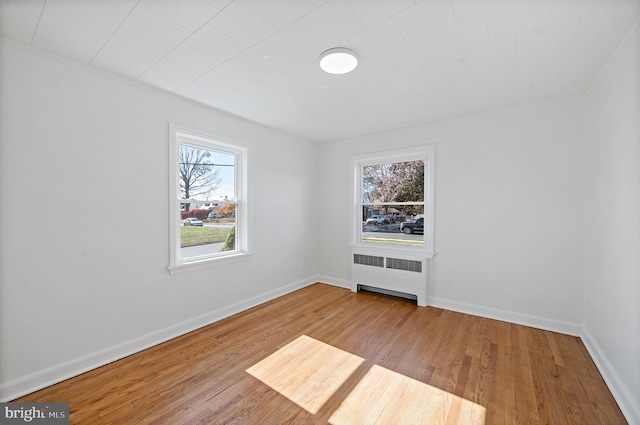 unfurnished room featuring light hardwood / wood-style flooring and radiator heating unit