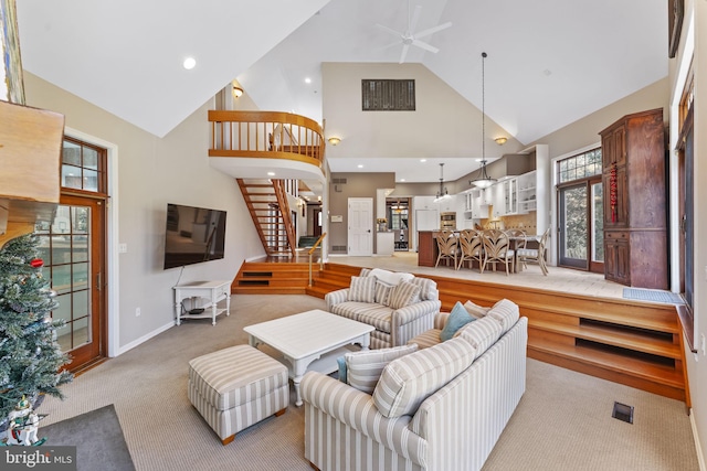 living room with light colored carpet, high vaulted ceiling, and ceiling fan