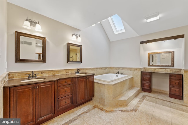 bathroom with vanity, a relaxing tiled tub, lofted ceiling with skylight, and tile patterned floors