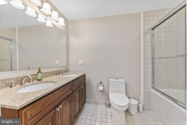 full bathroom featuring vanity, combined bath / shower with glass door, toilet, and tile patterned floors