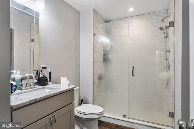 bathroom featuring vanity, walk in shower, toilet, and hardwood / wood-style flooring