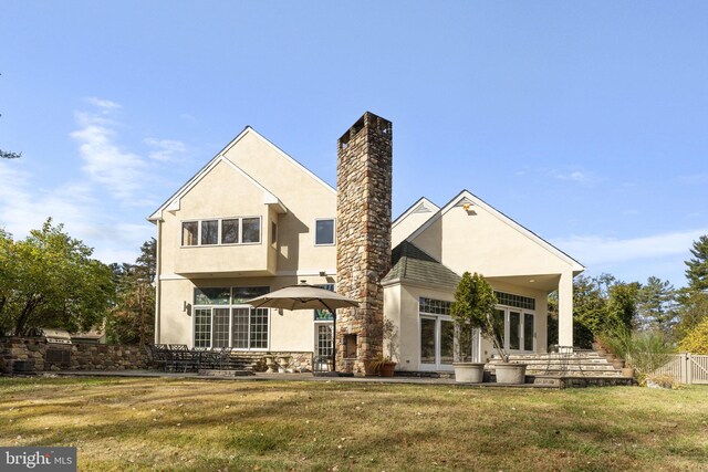 back of property with a patio and a lawn