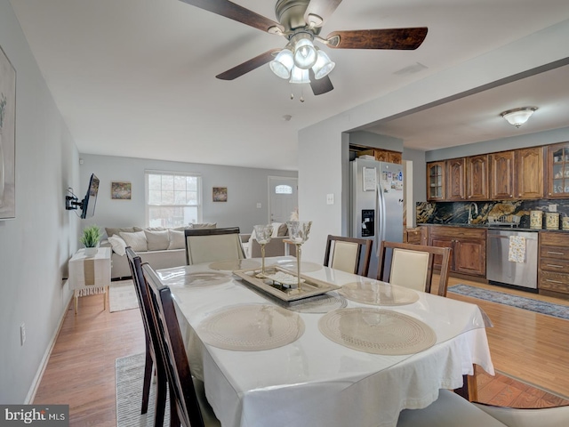 dining room with ceiling fan, baseboards, and light wood-style floors