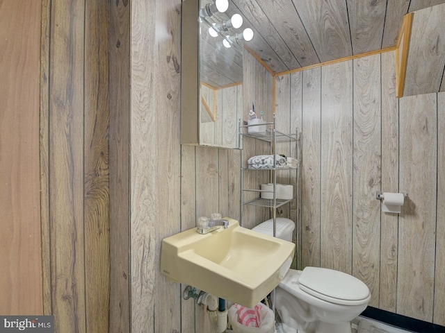 9321 Linhurst Dr, Clinton, MD 20735 - half bathroom featuring wood walls, toilet, a sink, and wood ceiling