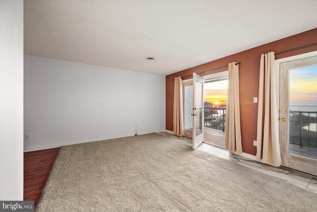 carpeted spare room featuring a textured ceiling and plenty of natural light