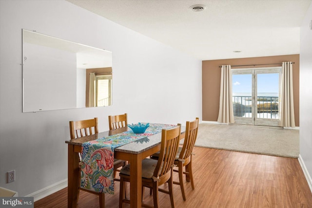 dining room with a water view and hardwood / wood-style floors