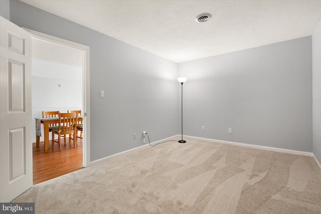 carpeted spare room with a textured ceiling