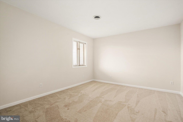 spare room featuring light carpet