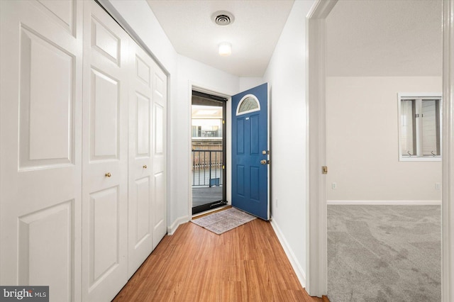 foyer with a textured ceiling and light wood-type flooring