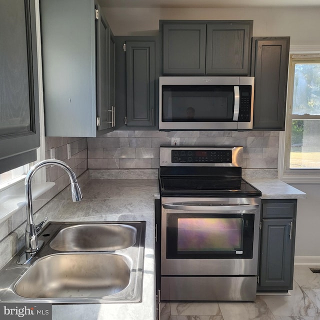 kitchen with decorative backsplash, sink, and appliances with stainless steel finishes