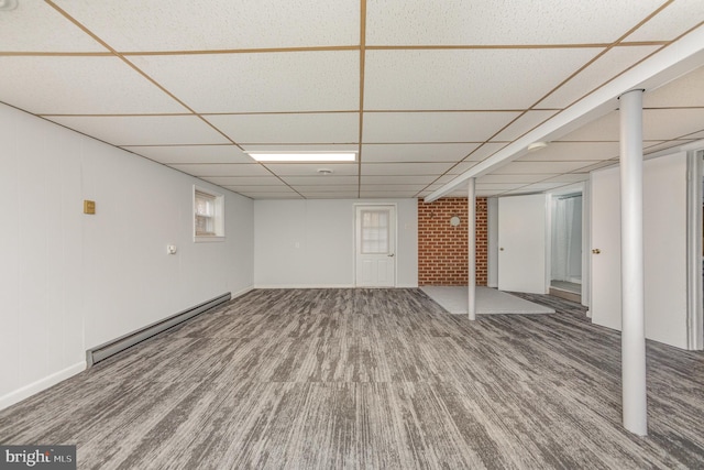 basement featuring hardwood / wood-style floors, a paneled ceiling, and a baseboard heating unit