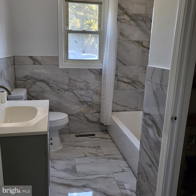 bathroom featuring vanity, tile walls, and toilet