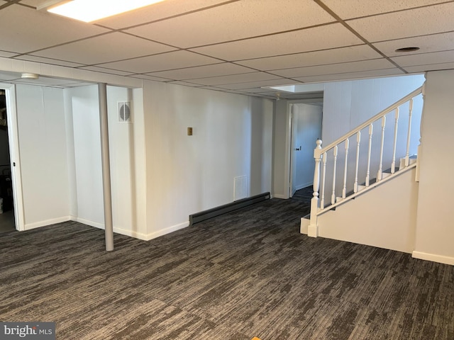 basement featuring dark hardwood / wood-style flooring and a paneled ceiling