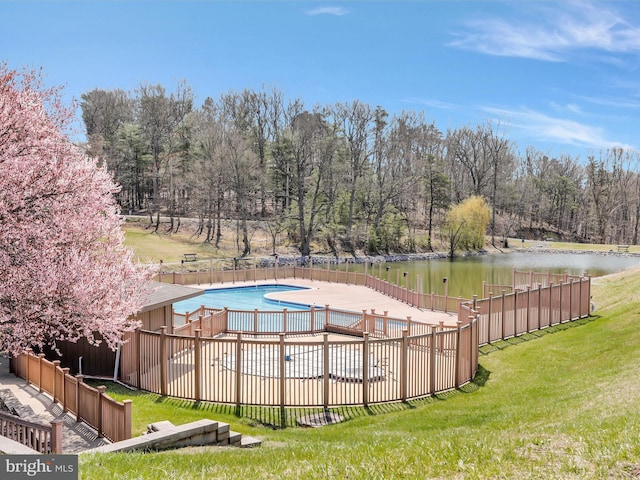 view of swimming pool with a lawn and a water view