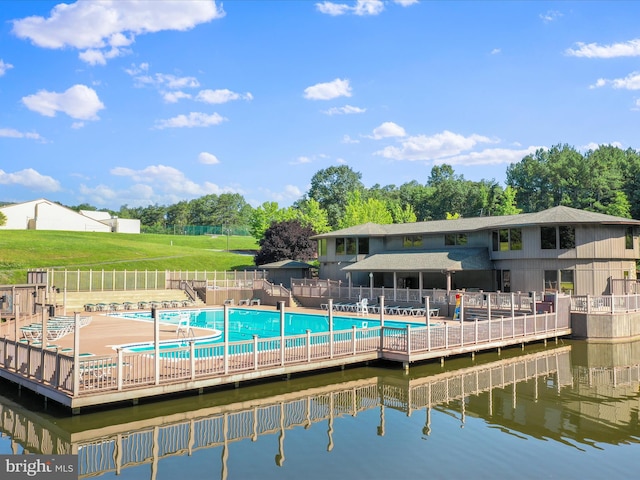 exterior space with a patio area, a water view, a community pool, and a lawn