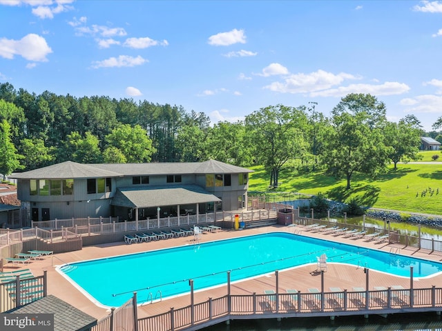 view of swimming pool with a yard