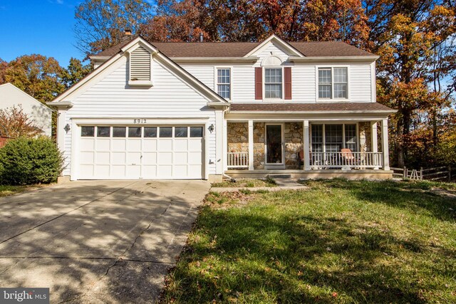 view of property with a garage, covered porch, and a front lawn