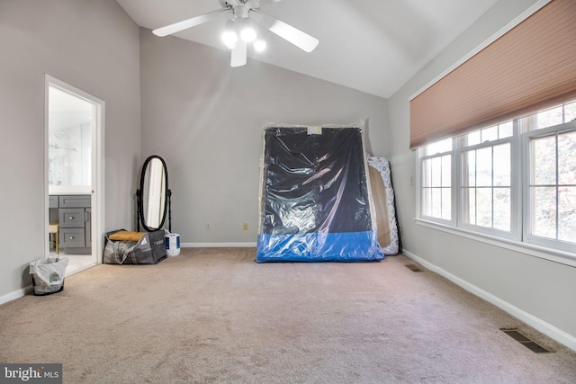 unfurnished bedroom featuring ceiling fan, ensuite bath, vaulted ceiling, and carpet