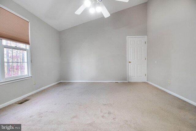 carpeted empty room with lofted ceiling and ceiling fan