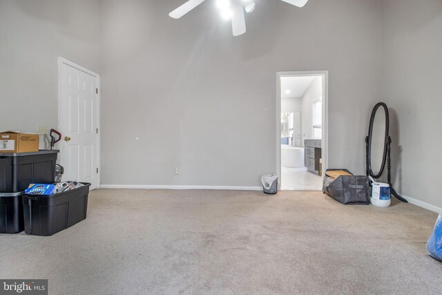 interior space featuring ceiling fan, high vaulted ceiling, and carpet