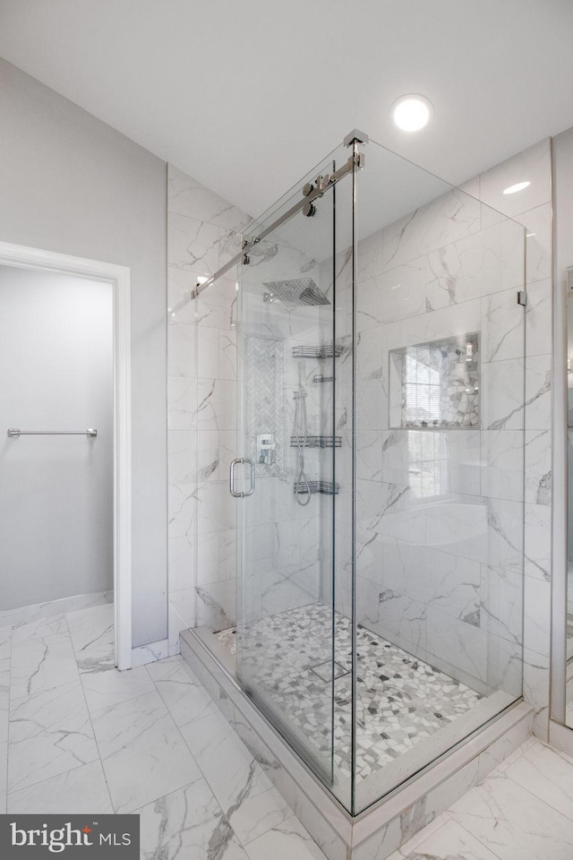 bathroom featuring a shower with door