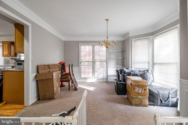 carpeted dining room featuring ornamental molding and an inviting chandelier