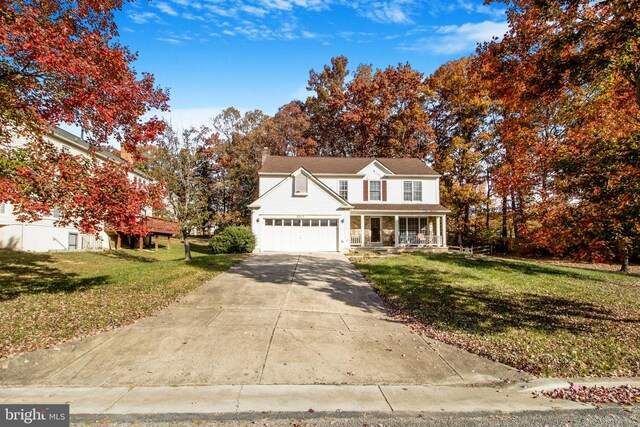 view of front property featuring a front lawn, a garage, and covered porch